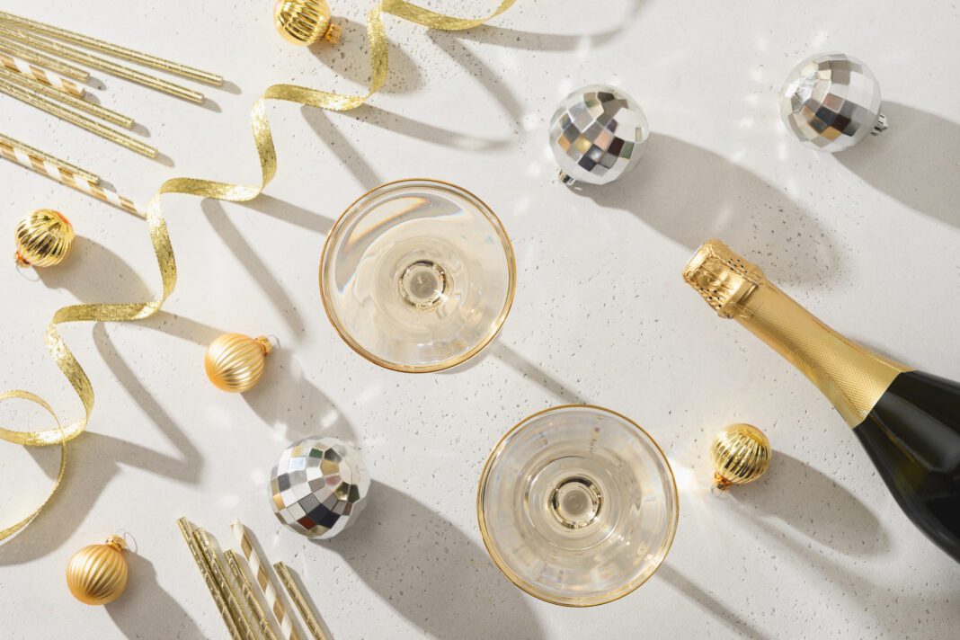 Festive New Year champagne and Christmas silver baubles on white background.