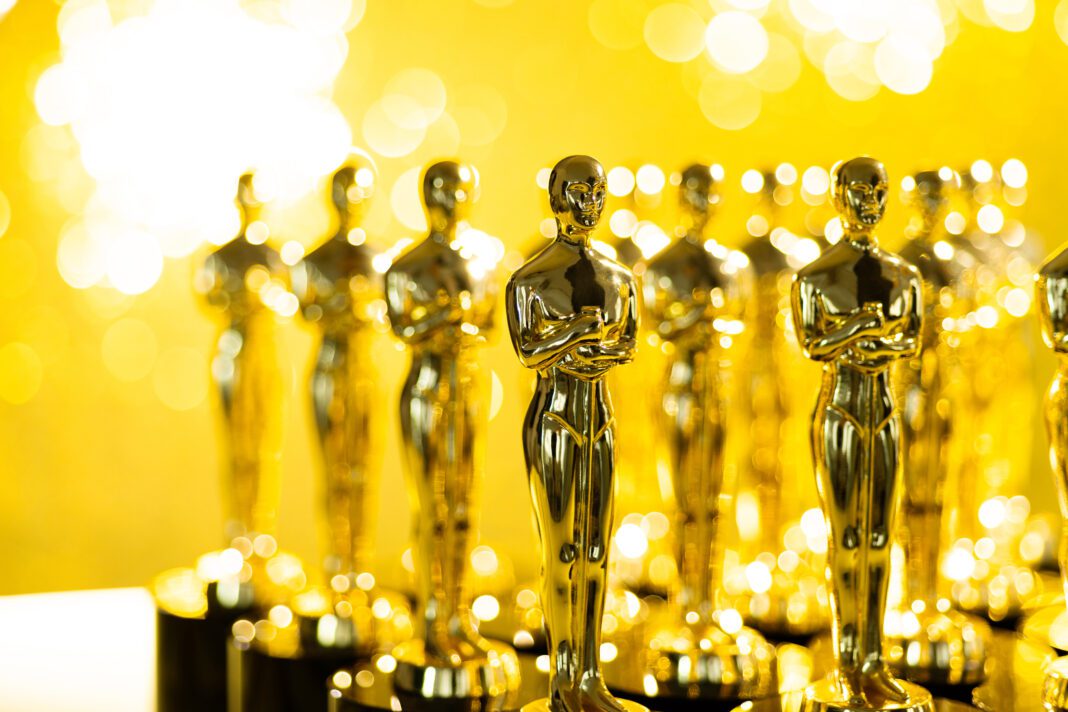 Group of golden statuette on shiny yellow background