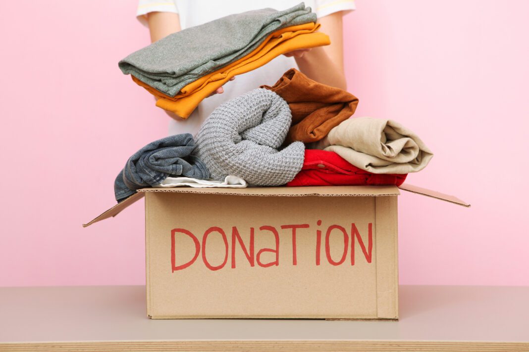 girl puts in a box with donations items. Volunteering