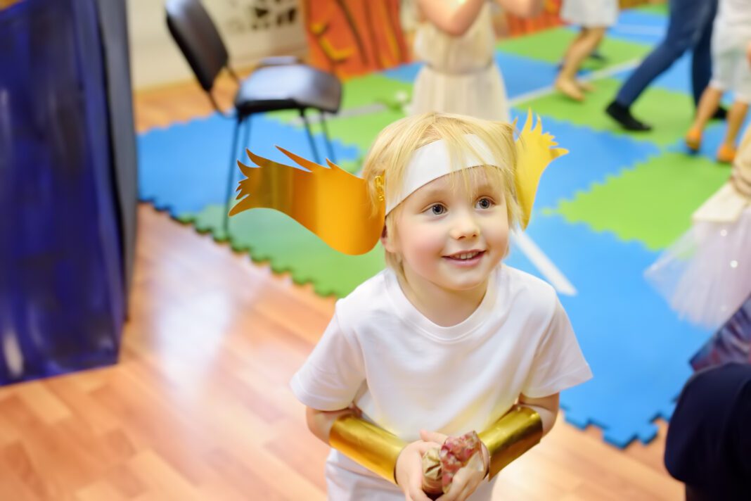 Little boy having fun on drama class or theatre Studio. Children playing greek heroes.